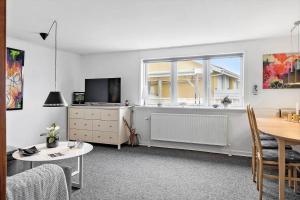 a living room with a table and a tv and a window at 70035-Ulfborg-Vinkelvej-2 in Thorsminde