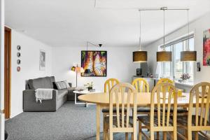 a dining room and living room with a table and chairs at 70035-Ulfborg-Vinkelvej-2 in Thorsminde