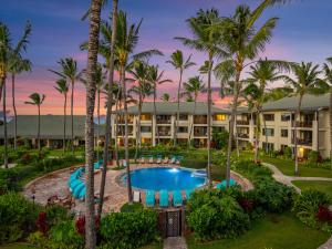 an exterior view of a resort with a pool and palm trees at 4-Bed Combination Villa 305-306 at Turtle Bay in Kahuku
