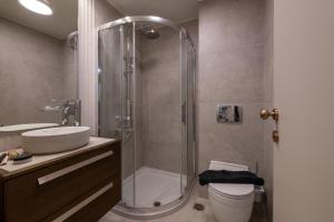 a bathroom with a shower and a toilet and a sink at Elaura luxury residences 2 in Kalamata