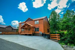 drewniany dom z dużym podjazdem w obiekcie Whispering Pines Escape - Private Pool, Theater Room, Outdoor Hot Tub + Game Room w mieście Sevierville