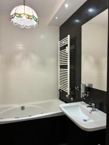 a bathroom with a white tub and a sink at Deluxe Apartament na wyłączność z darmowym parkingiem w garażu fv in Warsaw