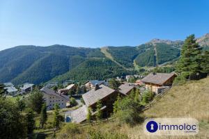un pueblo en una colina con montañas en el fondo en Charming studio in Auron, en Auron