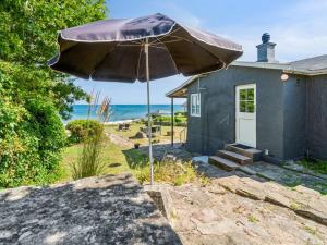 アリンエにあるHoliday Home Silke - 10m from the sea by Interhomeの傘を前に置いた青い家