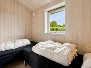 two beds in a room with a window at Holiday Home Tayana - 700m from the sea by Interhome in Neder Lysabild