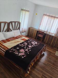 a bedroom with a bed with a black blanket with flowers at Ken valley homes & villa in Lovedale