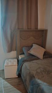 a bed with a wooden headboard in a room at Pousada Vida & Brisa in Pelotas