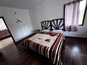 a bedroom with a bed with a striped blanket at Ken valley homes & villa in Lovedale