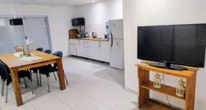 ein Wohnzimmer mit einem Tisch und einem TV auf dem Tisch in der Unterkunft Che Kerecha- Casa quinta in Riachuelo