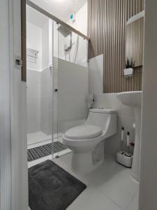 a white bathroom with a toilet and a sink at Studio Condo at Victoria Sports Tower, Quezon City in Quezon City