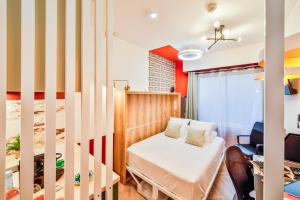 una habitación pequeña con una cama y un escritorio en WS Montparnasse - Maine, en París