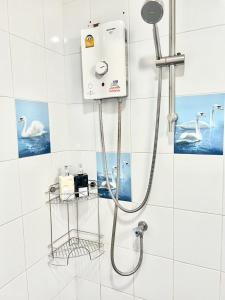 a shower in a bathroom with white tiles at Everything Within Minutes House in Bangkok +52 photos