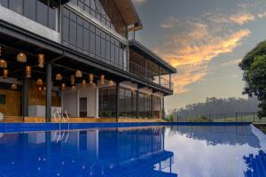 a building with a swimming pool in front of it at WelcomHeritage Ayatana Ooty in Ooty