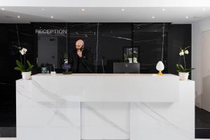 a man standing in front of a reception desk at Eurogarden Hotel in Rome
