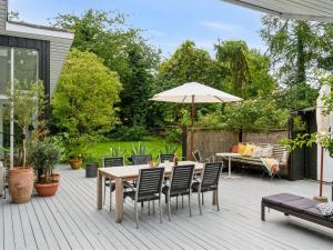 a patio with a table and chairs and an umbrella at Holiday Home Ivar - 150m from the sea by Interhome in Neksø