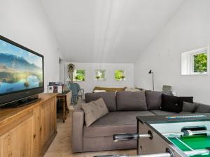 a living room with a couch and a flat screen tv at Holiday Home Ivar - 150m from the sea by Interhome in Neksø +22 photos