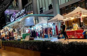 a man walking past a store in a city at night at Everything Within Minutes House in Bangkok