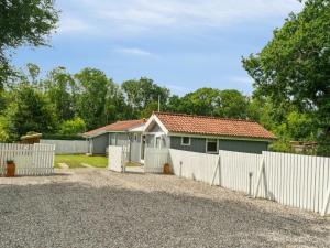 a house with a white fence next to a driveway at Holiday Home Salvina - 300m from the sea by Interhome in Odder