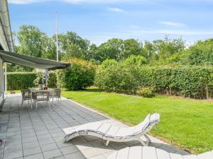 a patio with a table and a bench in a yard at Holiday Home Salvina - 300m from the sea by Interhome in Odder