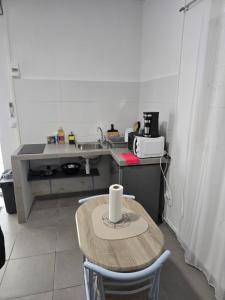a small kitchen with a table and a sink at Studio meublé 9 in Cayenne