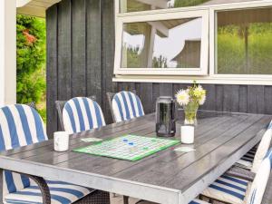 a gray table with blue and white chairs around it at Holiday Home Eljena - 700m from the sea by Interhome in Neder Lysabild