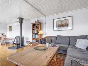 a living room with a couch and a table at Holiday Home Tenho - 150m from the sea by Interhome in Strøby