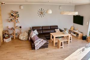 a living room with a leather couch and a table at Dom Ci Spokój in Czudec