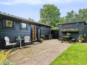 a tiny house with a patio and a table and chairs at Holiday Home Bedine - 1-3km from the sea by Interhome in Gilleleje