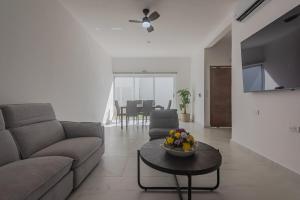 un soggiorno con un divano e un tavolo di Malibu Residential 3BD - Lia a Cozumel