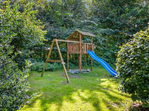 a playground with a slide and a swing at Holiday Home Jolin - 13km from the sea by Interhome in Skærbæk