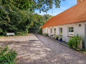a house with an orange roof and a gravel driveway at Holiday Home Jolin - 13km from the sea by Interhome in Skærbæk