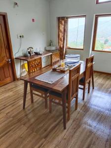 a dining room with a wooden table and chairs at Ken valley homes & villa in Lovedale