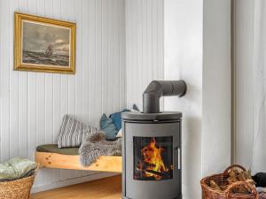 a wood stove with a fire in a room at Holiday Home Dagny - 520m from the sea by Interhome in Læsø