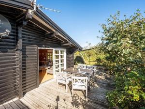 a patio with a table and chairs on a wooden deck at Holiday Home Christl - 500m from the sea by Interhome in Henne Strand +18 photos