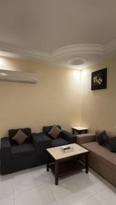 a living room with a couch and a coffee table at جراند خيال للشقق المخدومة in Abha