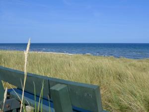 Un banco sentado en la playa junto al océano. en Holiday Home Jaane - from the sea by Interhome, en Hals