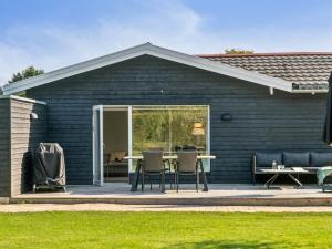 ein Haus mit einer Terrasse mit Tisch und Stühlen in der Unterkunft Holiday Home Frede - 1km from the sea by Interhome in Dronningmølle + 24 Fotos