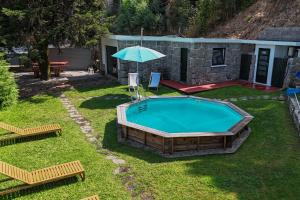 a swimming pool with an umbrella in a yard at Casa Veraneio by LovelyStay in Santo Tirso