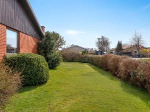 a yard with bushes next to a brick building at Holiday Home Natalija - 700m from the sea by Interhome in Ålbæk