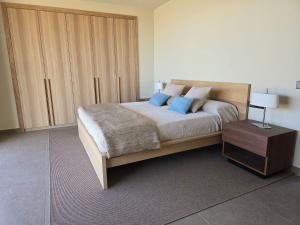 a bedroom with a large bed with blue pillows at Natural Beatriz Luxury Villa Baby Package Included in Lajares +9 photos