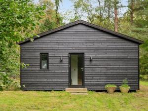 ein schwarzes Gebäude mit einer Tür im Hof in der Unterkunft Holiday Home Andresine - 1-3km from the sea by Interhome in Rørvig