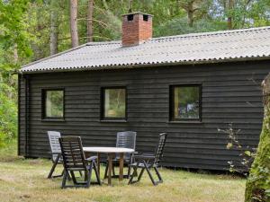 einen Tisch und Stühle vor einer Hütte in der Unterkunft Holiday Home Andresine - 1-3km from the sea by Interhome in Rørvig