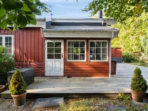 a small red house with a wooden deck at Holiday Home Galathea - 175m from the sea by Interhome in Nykøbing Sjælland +20 photos