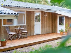 a cabin with a wooden deck with a table and chairs at Holiday Home Arto - 1-2km from the sea by Interhome in Vig