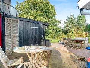 a patio with a table and chairs on a deck at Holiday Home Heraldine - 400m from the sea by Interhome in Stubbekøbing