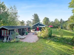 a garden with two buildings and a patio at Holiday Home Heraldine - 400m from the sea by Interhome in Stubbekøbing