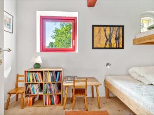 a bedroom with a bed and a desk and a table at Holiday Home Waldemar - 8km from the sea by Interhome in Gudhjem +19 photos