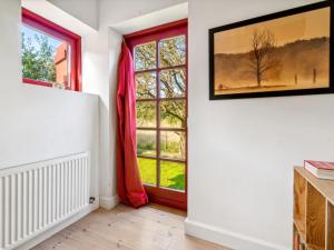 a room with a window with red curtains at Holiday Home Waldemar - 8km from the sea by Interhome in Gudhjem