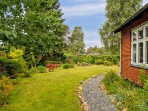 a garden next to a brick house with a yard at Holiday Home Saja - 550m from the sea by Interhome in Børkop
