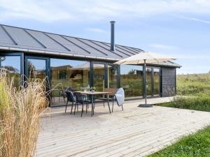 Holiday Home Aatos - 250m from the sea by Interhome في Knebel: سطح خشبي مع طاولة ومظلة